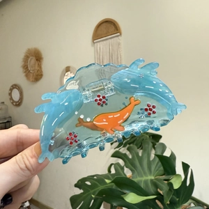 Blue whale hair claw clip made of clear acetate with sparkling red crystal flower accents