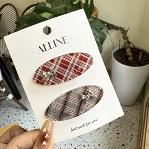 Set of two red and grey plaid acrylic hair clips with silver metal bow decorations