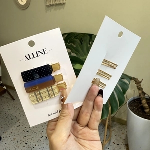 Close-up of a three-piece set of polka dot and plaid patterned resin duckbill hair clips