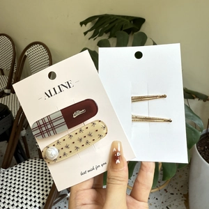 Vue détaillée des barrettes style coréen avec perles, motifs à carreaux et fini doré chic