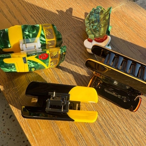 Detailed set of four acetate hair claws including bus and hand shapes on wood table