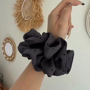 Detailed close-up of premium grey polka dot scrunchie fabric and thick pleated texture