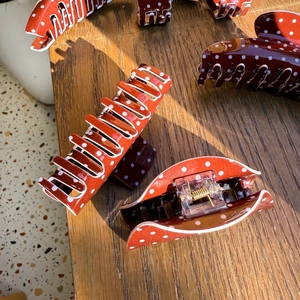 Detailed view of coffee blue polka dot resin hair claws with a strong gold metal spring