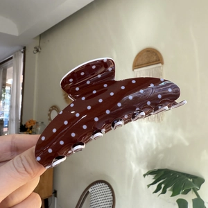 Brown hair claw clip with white polka dots featuring an elegant curved cloud design