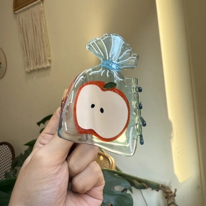 Pince à cheveux en acétate avec motif pomme transparent et design pochette bleue