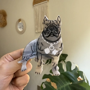 Détail d'une pince à cheveux bouledogue en acétate marbré gris tenue à la main