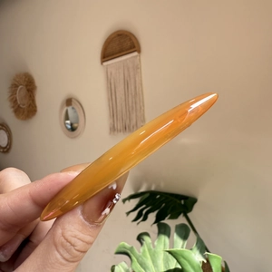 Pince à cheveux ou outil de massage en acétate ambré dans un décor de maison bohème