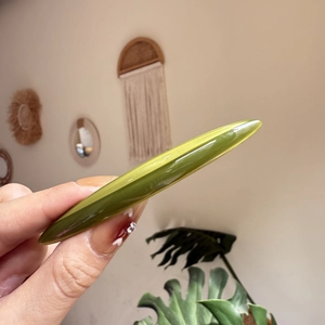 Barrette à cheveux longue en acétate vert olive brillant tenue pour montrer la taille