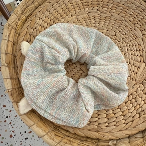 Dettaglio di un elastico per capelli in maglia colorata con trama punteggiata