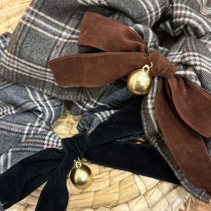 Macro shot of velvet bows with metallic gold balls on British style checkered hair scrunchies