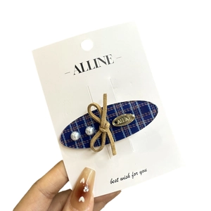 Blue plaid fabric hair clip with white pearls and brown velvet bow on display card