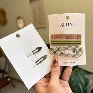 Détail d'un lot de barrettes à cheveux à carreaux avec un clip rectangulaire et un en goutte