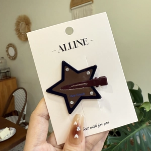 Star-shaped duckbill hair clip with diamonds and brown black color contrast on brand card