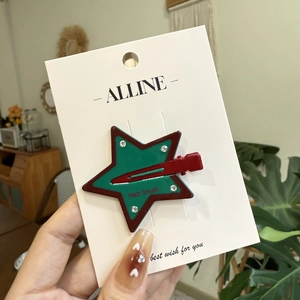 Detail of star-shaped hair clip with inlaid rhinestones on an Alline display card