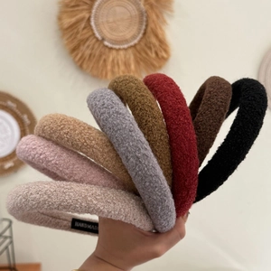 Gros plan détaillé de serre-têtes en peluche épaisse de couleurs variées avec étiquettes