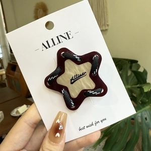Pince à cheveux étoile avec design tressé rouge et blanc sur carte Alline