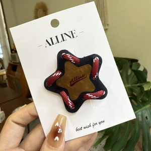 Détail d'une pince à cheveux étoile bleue avec centre en cuir et cordon tressé