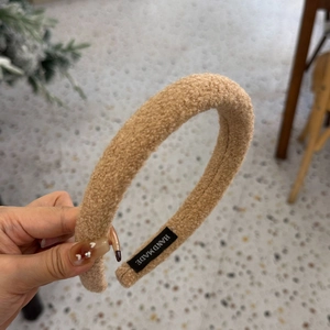 Détail de l'étiquette tissée à la main sur un serre-tête en peluche marron pour l'hiver