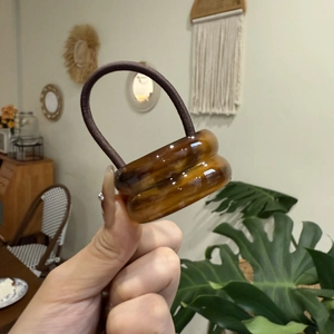 Close-up of dual amber acrylic rings on a high-elastic brown hair tie for women