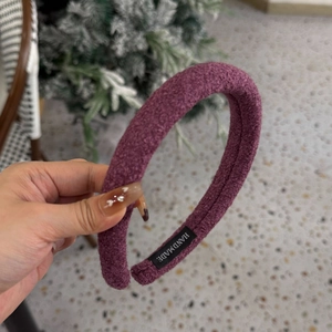 Détail du bandeau en peluche violette avec étiquette fait main et texture douce