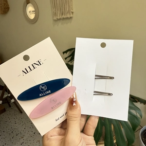 Close-up of pink and navy resin hair clips with metal duckbill structure detail