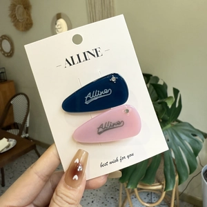 Set of pink and dark blue droplet hair clips with rhinestones on a brand card display