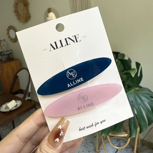 Close-up of pink and navy blue seamless bow hair clips on a white display card