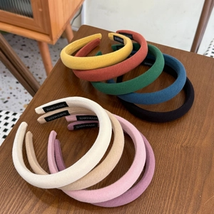 Detail showing various colors of thick sponge headbands with handmade cloth labels