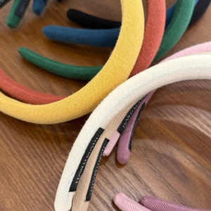 Detail of multi-color knitted sponge headbands showing textures and hand made label