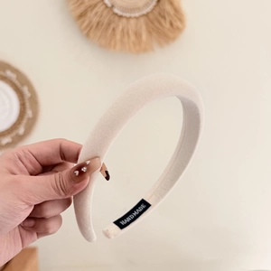 Thick cream fabric sponge headband with handmade label shown in a lifestyle setting