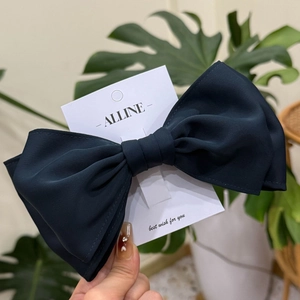 Elegant large navy blue silk texture bow hair clip displayed on a branded card