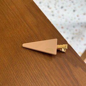 Minimalist beige triangle hair clip with France Handmade engraving on wooden table