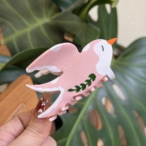 Pink bird-shaped acetate hair claw clip with green leaf pattern for elegant styling