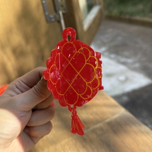Detail van rode haarklem met Chinees knoopontwerp en gouden accenten met een kwastje