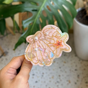 Pink ocean seashell claw clip with iridescent marbling and pearl starfish accents
