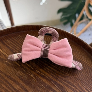 Pince à cheveux rose avec nœud et motif à carreaux pour une coiffure élégante