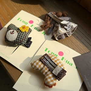 Detail of handmade fabric hair clips with green plaid frog and floral girl doll patterns