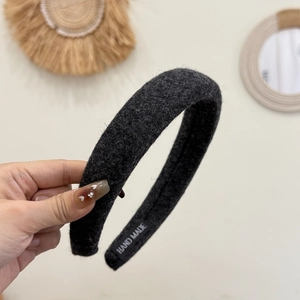 Detail of hand made thick wool headband showing the fabric texture and inner label