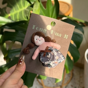 Detail showing a handmade fabric doll hair clip on a Tong Hua Ji brand craft card