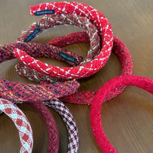 Detail of red tweed headbands with handmade labels and textured woven fabric for women