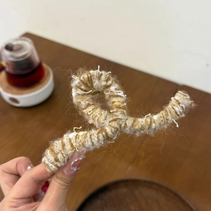 Knitted wrap claw clip in brown and beige yarn with wavy metal frame for autumn