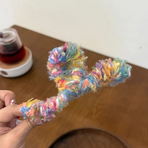 Close-up of colorful wool yarn wrapped claw clip with soft knitted texture for women