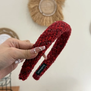 Detail of red tweed headband with golden threads and handmade label on soft inner lining