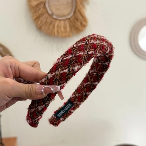Close-up of red plaid tweed headband with golden threads and handmade label detail