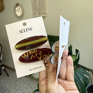 Detail of Korean-style acrylic hair clips featuring striped patterns and letter prints