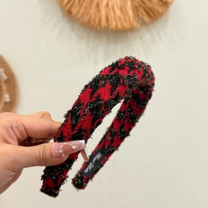 Macro detail of red plaid headband with golden threads and Hand Made label text