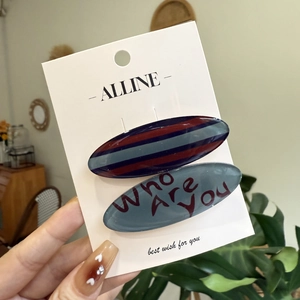 Striped oval hair clip set with artistic text on a white branded display card