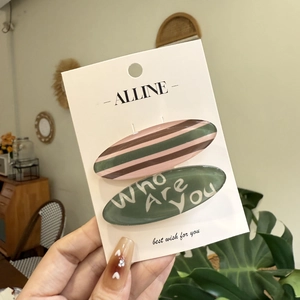 Pink and green striped hair clip set with text on elegant white display card