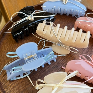 Close-up of acetic acid hair claws with ribbon bows and sparkling rhinestones