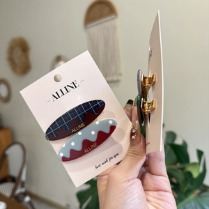 Detail of ALLINE hair clips featuring blue plaid and gray polka dot acetate patterns